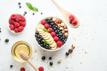 Healthy breakfast. Oatmeal with berries and fruits on a light background top view copy space.