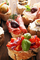 Appetizers table with italian antipasti snacks and wine in glasses. Brushetta or authentic traditional spanish tapas set, cheese variety