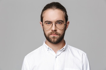 Obraz premium Man posing isolated over grey wall background wearing glasses.