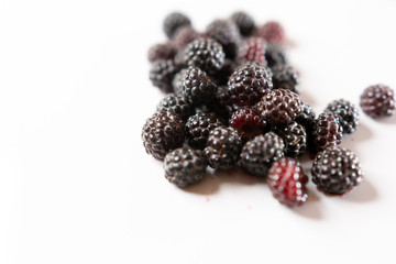 Fragrant sweet red and black raspberries on a white background.