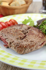 grilled ground beef steak and salad on a plate