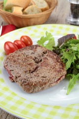 grilled ground beef steak and salad on a plate