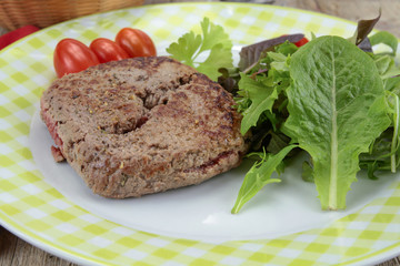 grilled ground beef steak and salad on a plate