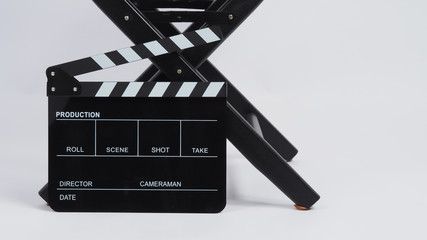 Fototapeta na wymiar Black Clapper board or movie slate with director chair use in video production or movie and cinema industry.It is put on white background.