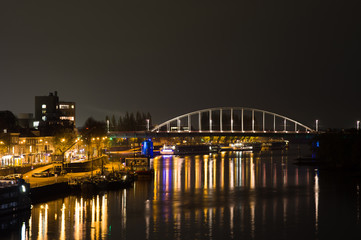 Fototapeta na wymiar Arnhem in the Netherlands, with the John Frost bridge at night with in the foreground the river Rhine