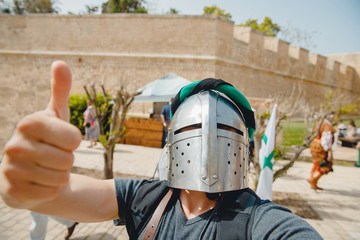 Selfie photo of male Viking cosplay in knight's helmet with armor Crusaders festival