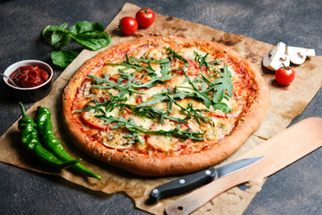 Traditional Italian pizza with eggplants, mozzarella, basil and tomatoes on a dark background copy space.
