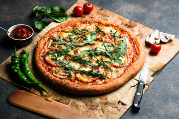 Traditional Italian pizza with eggplants, mozzarella, basil and tomatoes on a dark background copy...