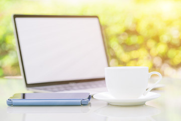 Coffee cup and laptop at office with smartphone