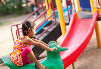 Fototapeta na wymiar Asian girls riding cartoons on the playground with fun on holiday