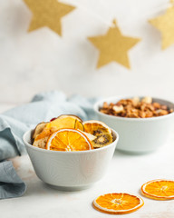dried fruits orange, banana, kiwi, pear, mango, strawberries in a blue bowl close-up on a light background with a blue textile napkin