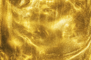 Abstract elegant, detailed gold glitter particles flow with shallow depth of field underwater....