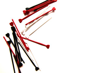 Plastic colorful sticks for canapes with a heart on a white isolated background. Copy space.