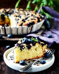 Cake with blueberries on a dark wooden background, still life