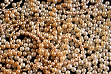 A pile of shiny pearl bead necklaces