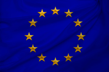 close-up photo of beautiful colored stylized European Union flag, symbol of united Europe on textured fabric, concept of tourism, emigration, economy and politics, close-up