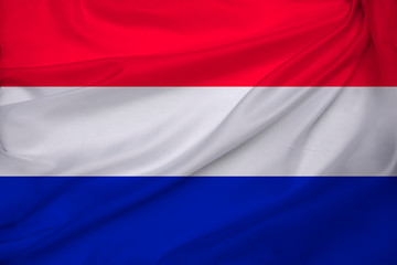 photo of the beautiful colored national flag of the modern state of the Netherlands on textural fabric, concept of tourism, economics and politics, closeup