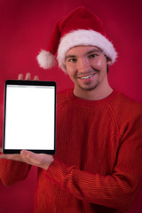 Chico joven con gorro navideño promocionando productos y ofertas con un tablet en sus manos.