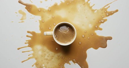 Top view of sugar cubes falling into mug of fresh cappuccino and splashing coffee ons white table in slow motion - Powered by Adobe