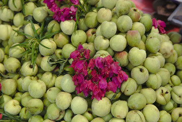 NB__7576 Green fruit decorated with flowers in market