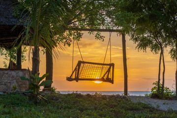 Wooden swing of beautiful sunset on the island of Zanzibar, Tanzania, East Africa
