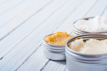 shea, macadamia nut  and coffee butter cream, skin care product samples on white wooden table