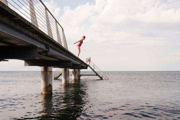 Woman about to jump off swimming pier