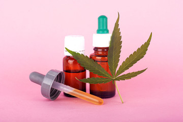 natural cannabis medicine, marijuana oil extract on pink background..