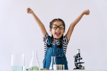 Little 6s cute girl wear glasses happy raise arms with microscope, laboratory bottle and water...