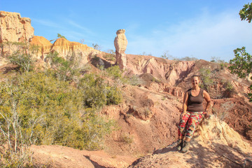 The famous attraction in Kenya is the gorge of Hell's Kitchen - stones and rocks with colorful sand near Marafa, Malindi. East Africa Erosion of sand cliffs. Caucasian girl tourist.