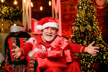 Obraz na płótnie Canvas Come here. Merry christmas. Grandpa at home. Traditions concept. Santa Claus near christmas tree. Bearded senior man Santa Claus. Santa Claus relaxing in arm chair. Delivering gifts. Winter vacation