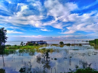 landscape with river and clouds, under the blue sky