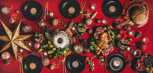 Celebration Christmas, New Year holiday. Flat-lay festive table with red cloth with sparkling wine, roasted turkey, bundt cake, fruit and decorations, top view. Winter holiday party