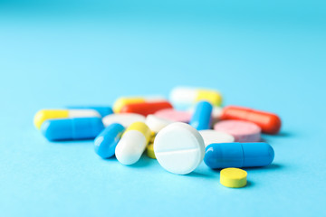 Many pills on blue background, closeup and space for text