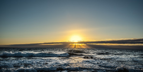 Rough sea and shining sun at sunset