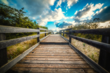 Wooden boardwalk by the sea at sunset