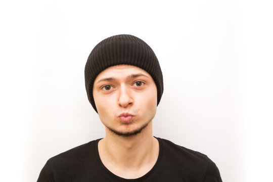 emotion kissing smiling eyes, young man in a black cap on a white background, man emoji