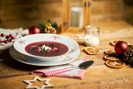 Traditional christmas red borscht on wooden table