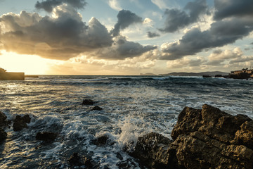 Rough sea in Alghero rocky shore at sunset