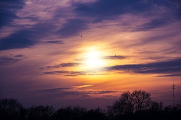 Obraz na płótnie Canvas Sun behind the clouds at sunset . Golden sun at sunset .