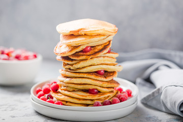 Homemade pancake or hot cake stacked on white plate with berry on grey stone Background,