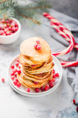 Homemade pancake or hot cake stacked on white plate with berry on grey stone Background, Christmas Dessert.
