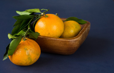 Mandarine fruite with leaves on a blue background