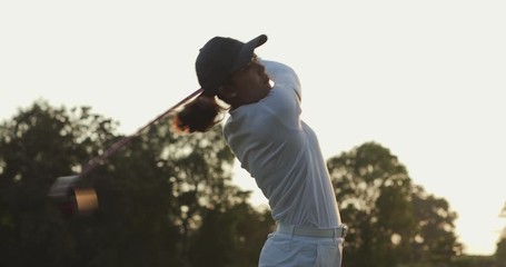Professional golfer playing golf course with sunset background. People, sport, leisure activity, recreation and lifestyle concept. Slow motion shot.