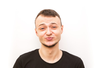 Fototapeta premium emotion kissing smiling eyes, young man in a black cap on a white background, man emoji
