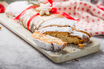 Stollen a traditional European cake with nuts and candied fruit, is dusted with icing sugar and cut into pieces