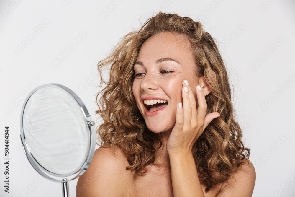 Wall mural image of excited half-naked woman smiling and looking at mirror