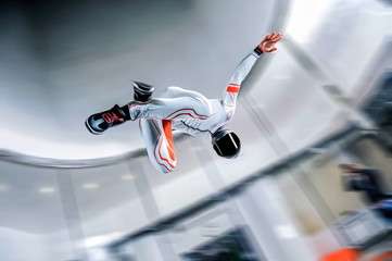 Indoor. Man fly in wind tunnel. Indoor skydiving. New fly sport.