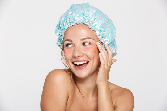 Image of woman wearing cosmetic patches and shower cap looking aside