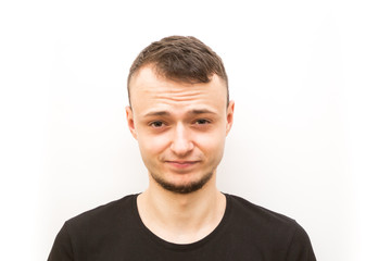Fototapeta premium emotion not amused, young man in a black cap on a white background, man emoji